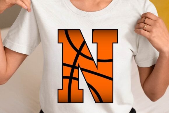 Person wearing a t-shirt with a large orange basketball-themed letter N
