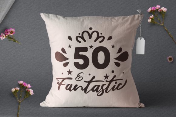White pillow featuring '50 & Fantastic' design with decorative elements and a crown.