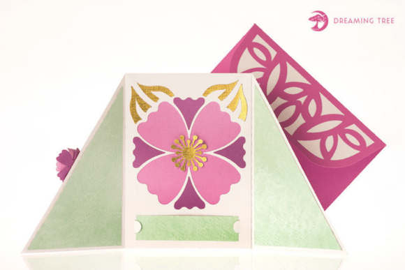 Opened gatefold card displaying a large pink flower with gold accents, set against a green background.