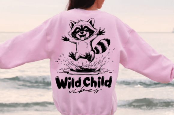Pink sweatshirt with a playful raccoon and 'Wild Child vibes' text, perfect for Cricut projects.