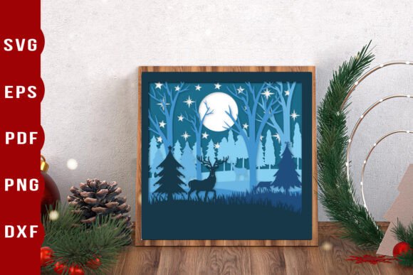 Framed papercut shadow box with deer, moon, and forest scene in blue tones.