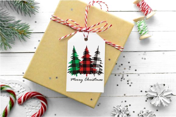 Gift tag with plaid Christmas trees and 'Merry Christmas' text, attached to a wrapped present with red twine.