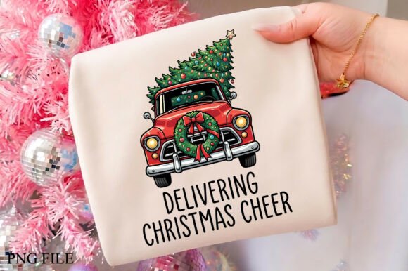 Hand holding a fabric with a red truck carrying a decorated Christmas tree and text 'Delivering Christmas Cheer'.