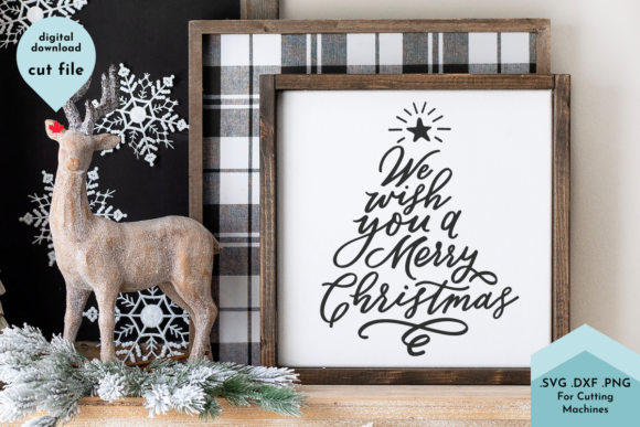 Hand lettered 'Wish You a Merry Christmas' SVG displayed in a wooden frame with a reindeer and tree decor, suitable for Cricut projects.