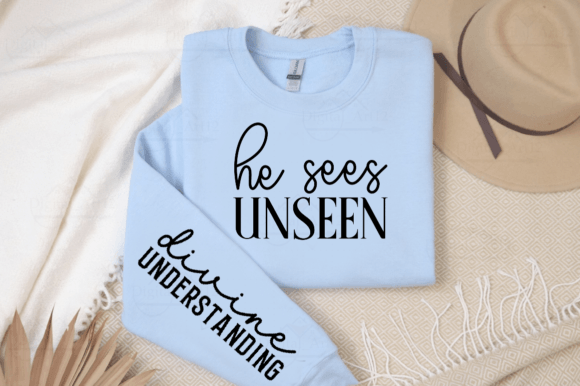 Light blue sweatshirt with 'he sees UNSEEN' on chest and 'divine UNDERSTANDING' on sleeve.