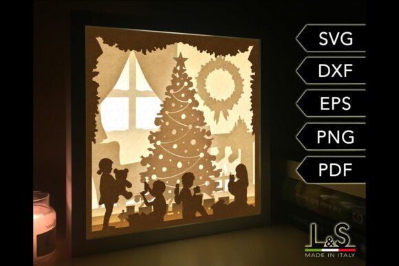 Illuminated shadow box showing children around a Christmas tree indoors.