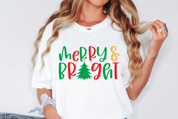Woman wearing a white t-shirt with 'Merry & Bright' and a Christmas tree design.