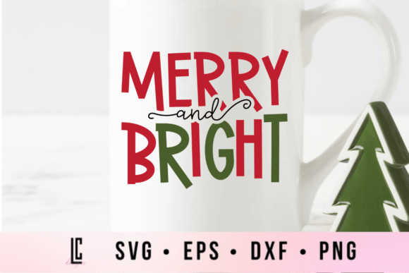 White mug with 'Merry and Bright' in red and green letters, next to a small green tree decoration.