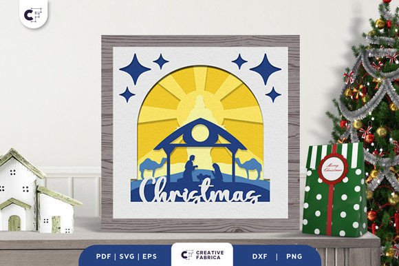 3D layered papercut of a nativity scene with stars, camels, and 'Christmas' text in a shadow box.