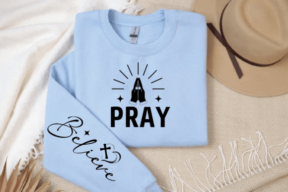Light blue sweatshirt with 'PRAY' and praying hands on front, 'Believe' and cross on sleeve.